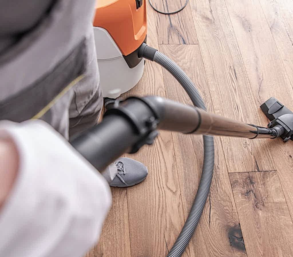 male-worker-vacuuming-hardwood-flooring-.jpg